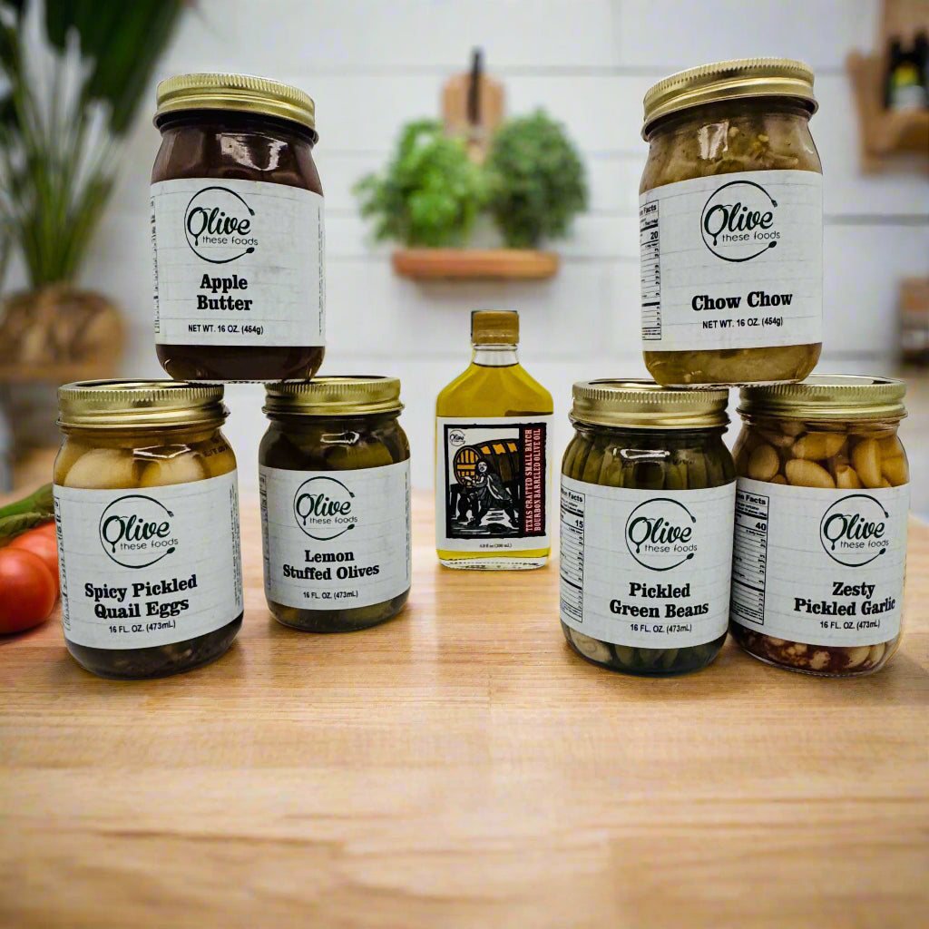 Assorted jars of Olive brand pickles and preserves on a white background